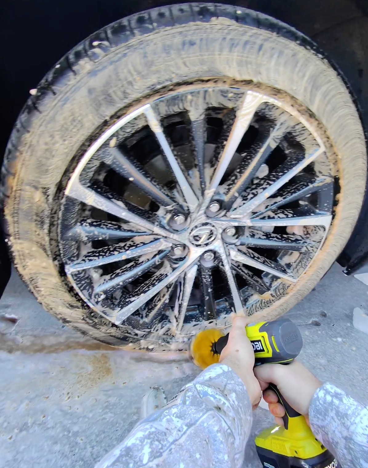 Lexus wheel being scrubbed with foam and a brush during the wash stage