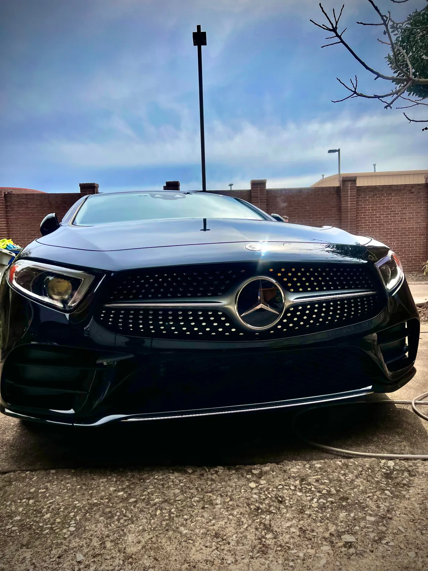 Mercedes-Benz CLS 450 front grille under blue sky after full detail
