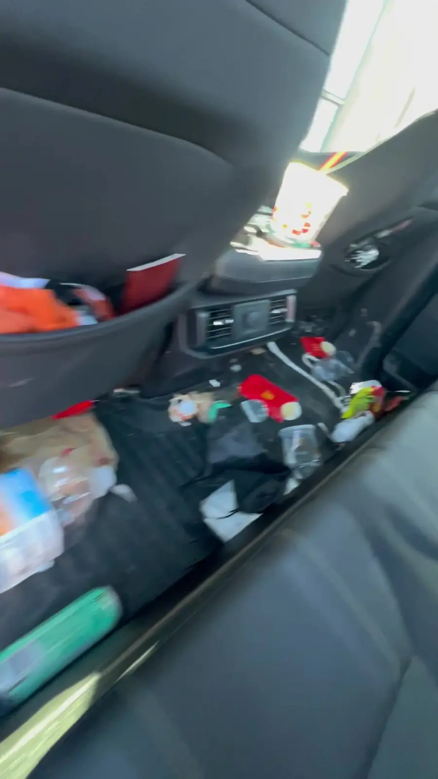 Rear cabin of the Ford F-150 before detailing, floor covered in trash and clutter