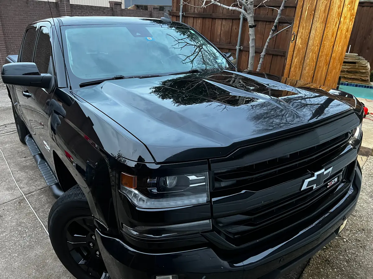 Chevy Silverado blacked-out front three-quarter hero shot with mirror reflections